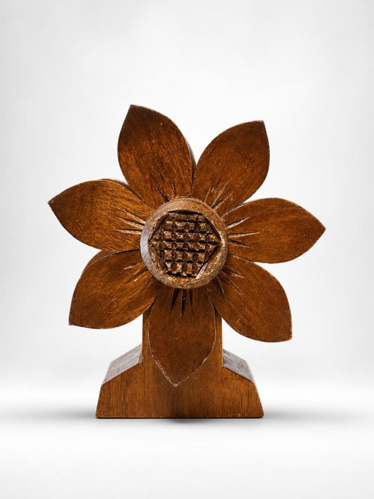 Front view of a 1970s vintage hand-carved wooden flower napkin holder with a stylized eight-petal design, a geometric cross-hatched center, and a flared pedestal base on a crisp white background.