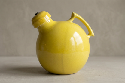 Yellow ceramic jug with warm greige studio background