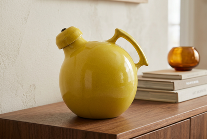 Yellow vintage ceramic jug styled on a walnut sideboard